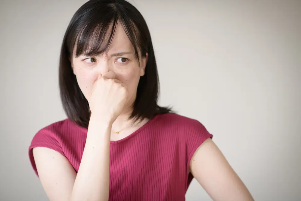 写真：鼻をつまむ女性