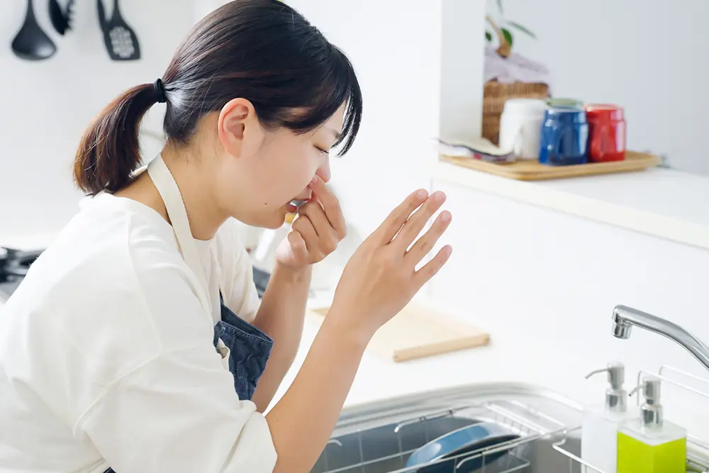 写真:キッチンが臭くて鼻をつまむ女性